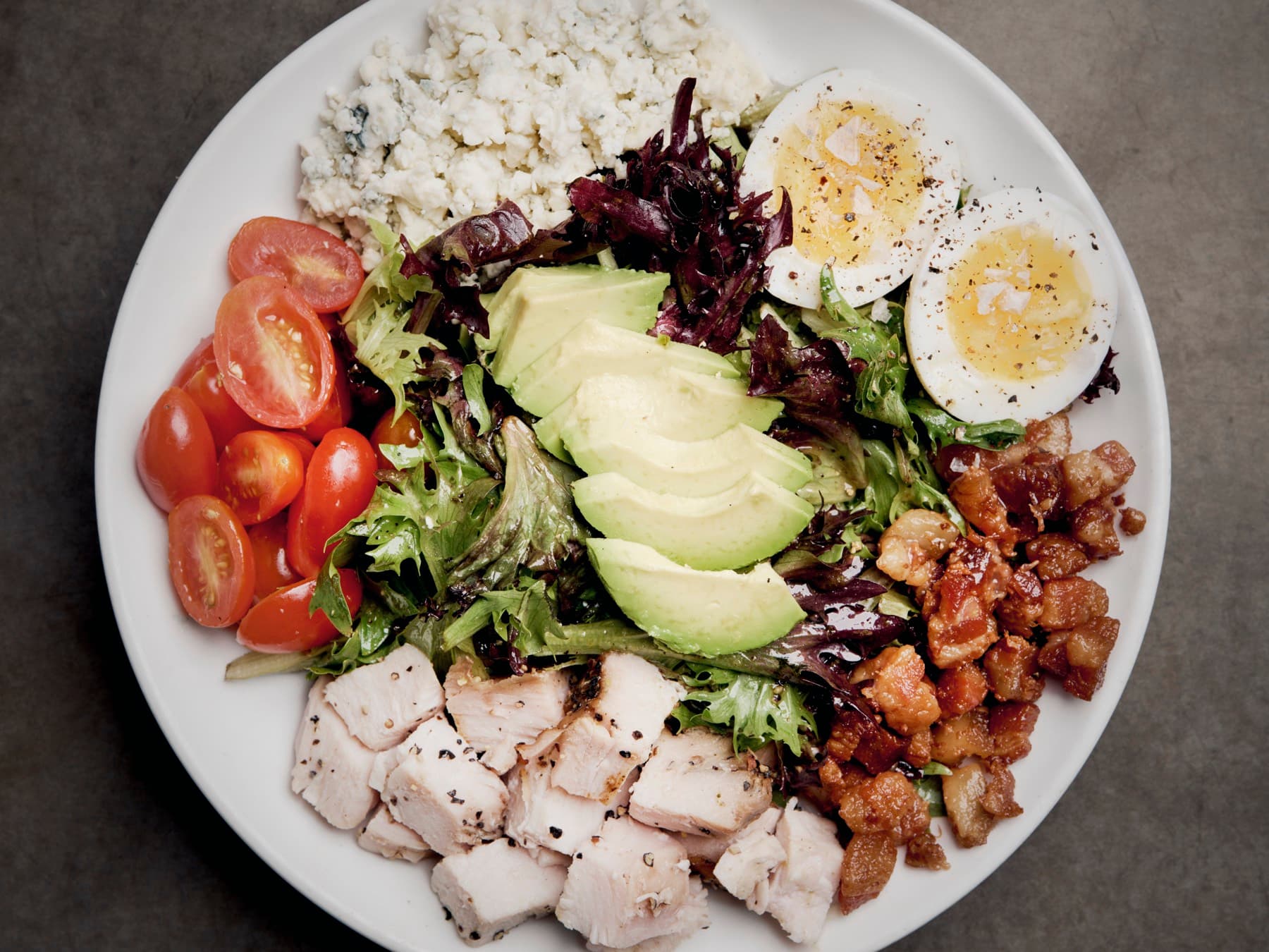 Cobb salad with avocado, jammy eggs, blue cheese, tomatoes, and bacon
