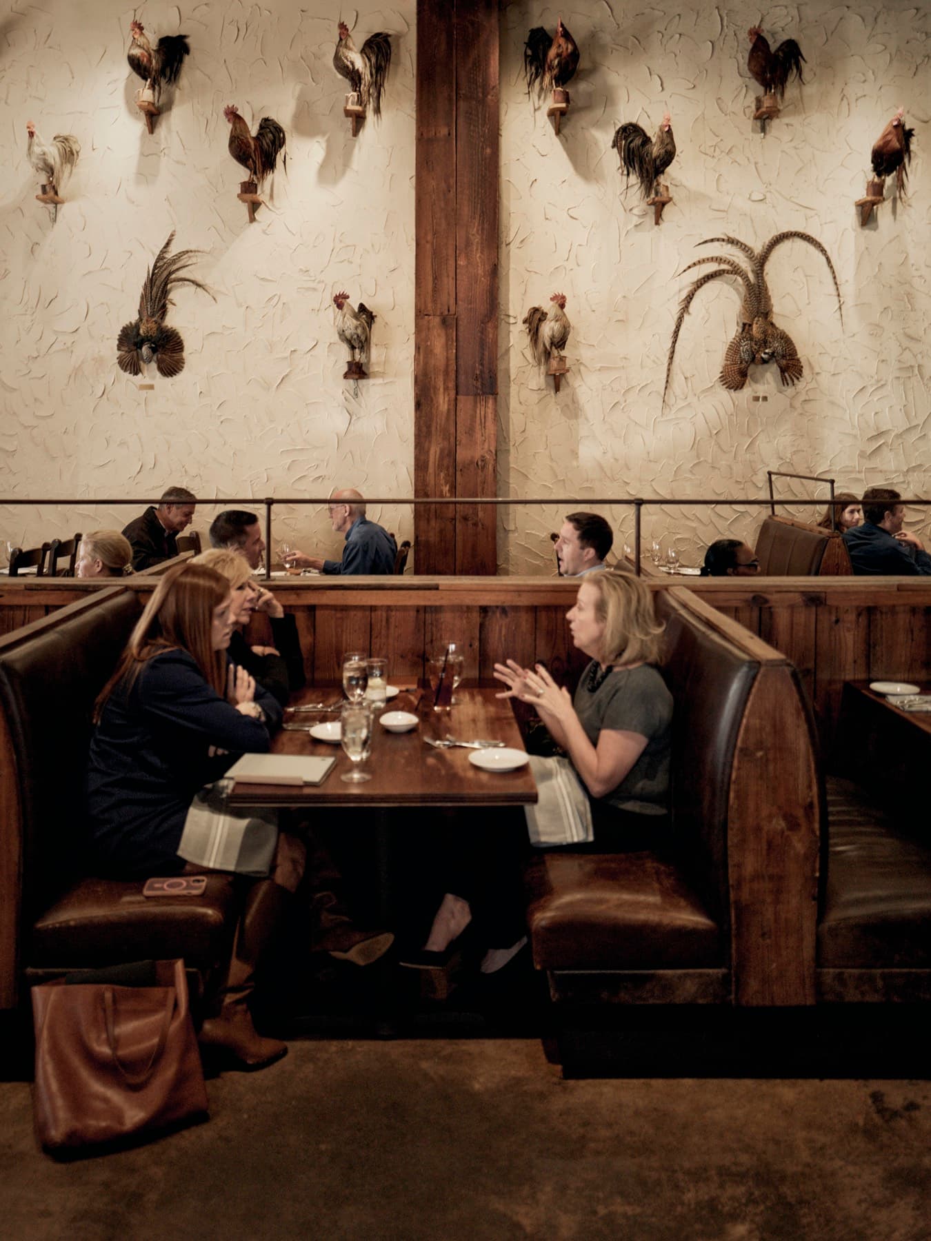 The SouthPark dining room, leather booths beneath the rooster plaster wall