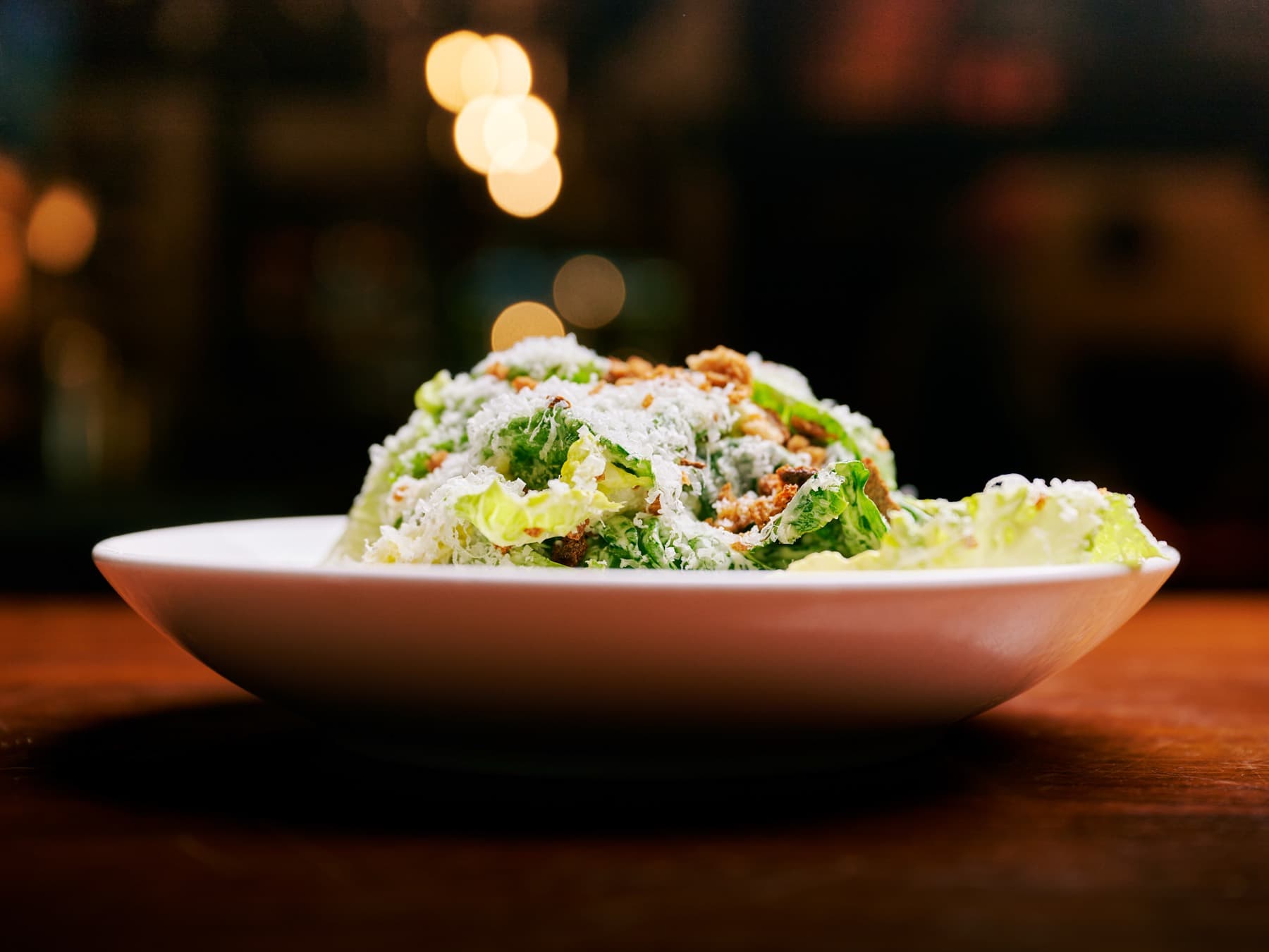 Caesar salad piled with shaved parmesan